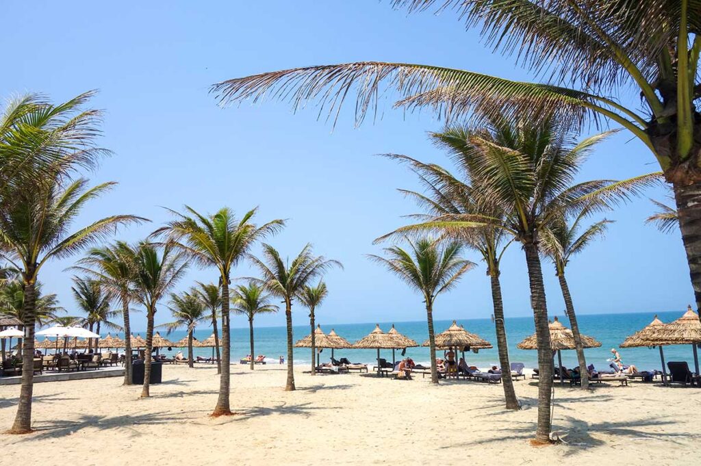 An Bang Beach near Hoi An with waving palm trees and clear blue sky