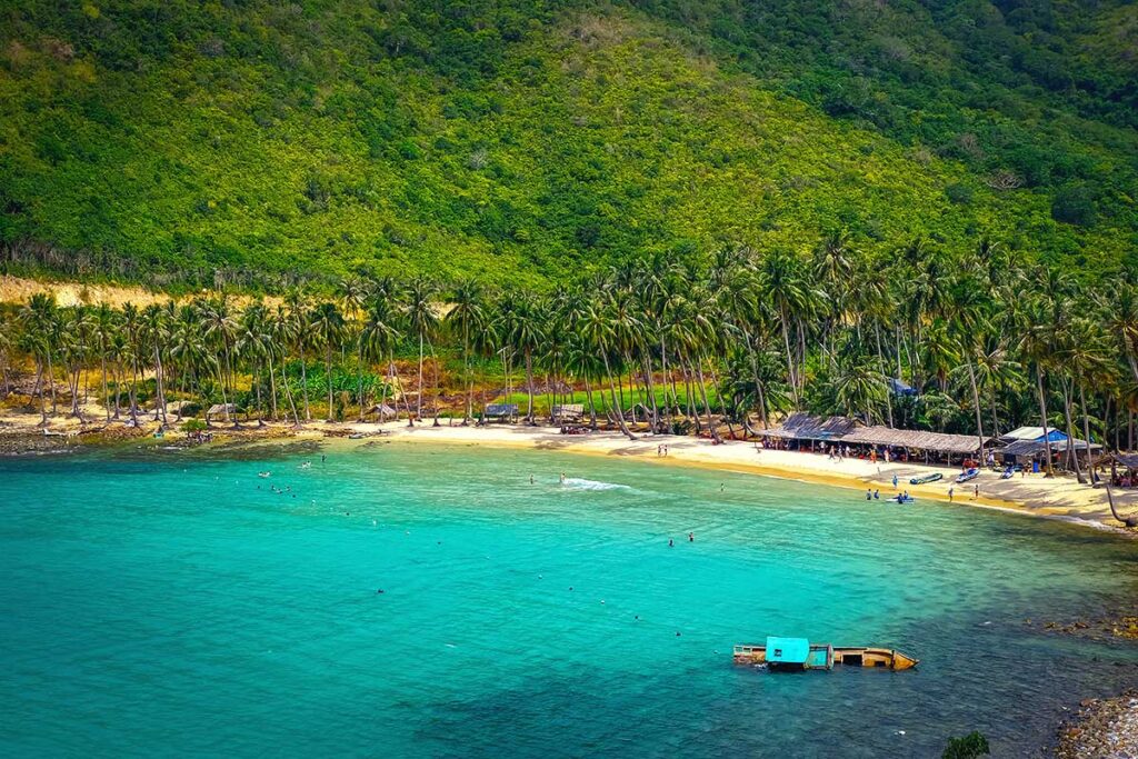 palms, blue water and white sand of Cay Men Beach on Nam Du Island near Phu Quoc