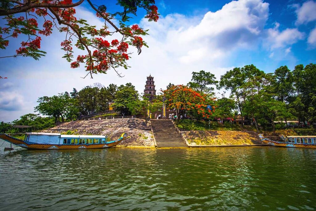 Two dragon boats parked on the Perfume River in front of the Thien Mu Pagoda in Hue.