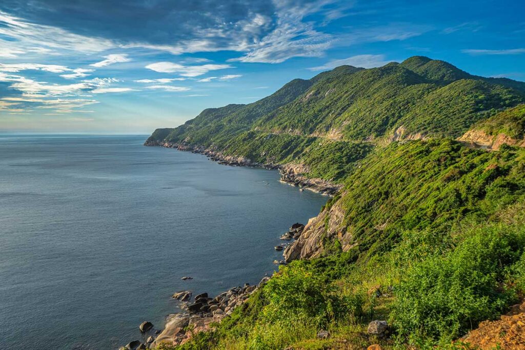 Scenic coastal road along Eo Gio on Cham Island, with rugged cliffs and deep blue sea creating one of the best viewpoints on the island.