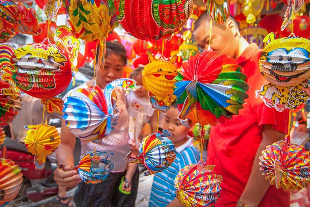 A kid is shopping with his dad for lanterns for Mid Autumn Festival in Hanoi