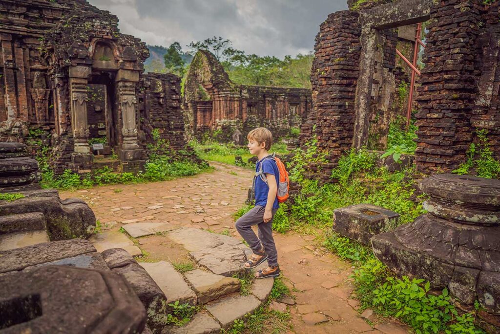 Hoi An with kids – young traveler exploring ancient ruins at My Son Sanctuary on a family day trip