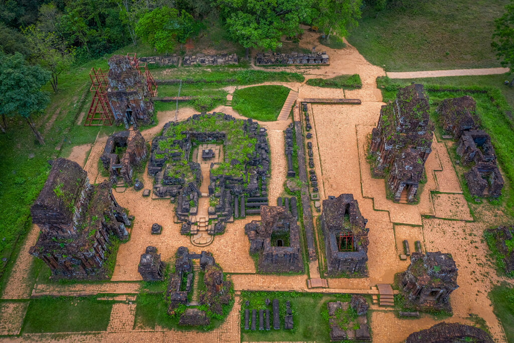 Drone view over the My Son Sanctuary archaeological site highlighting its isolated valley setting and layout of temple clusters.