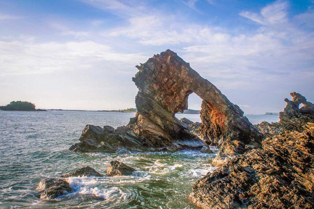 The dramatic black volcanic rocks of Ban Than on Tam Hai Island, a natural coastal landmark shaped by wind and waves.