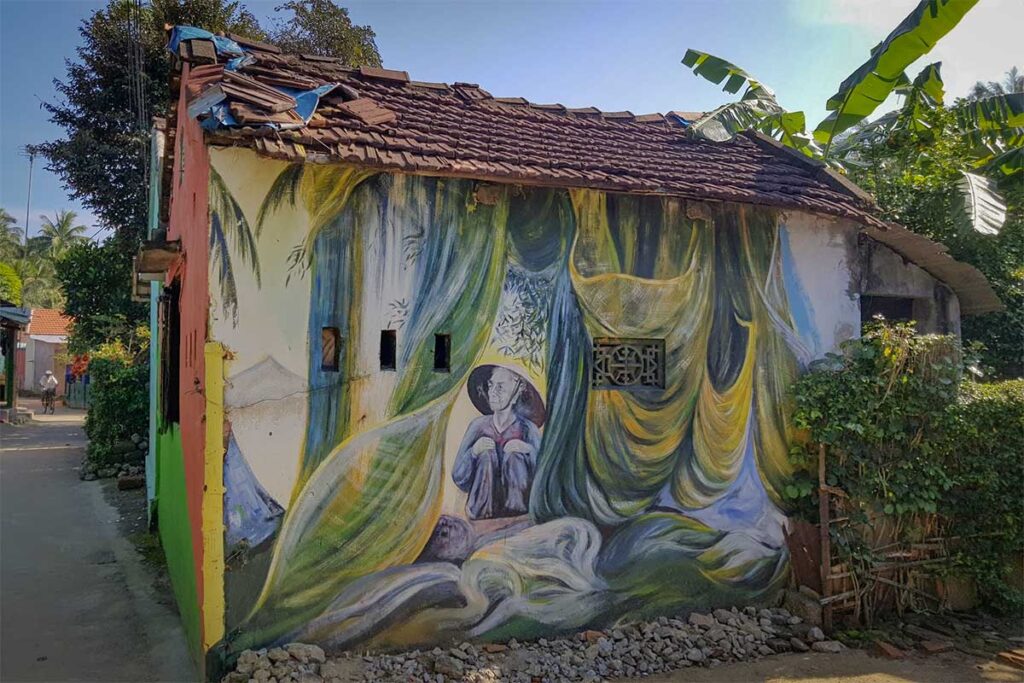 Artistic mural painted on an old village house in Tam Hai Island’s mural village, blending local life with creative coastal art.