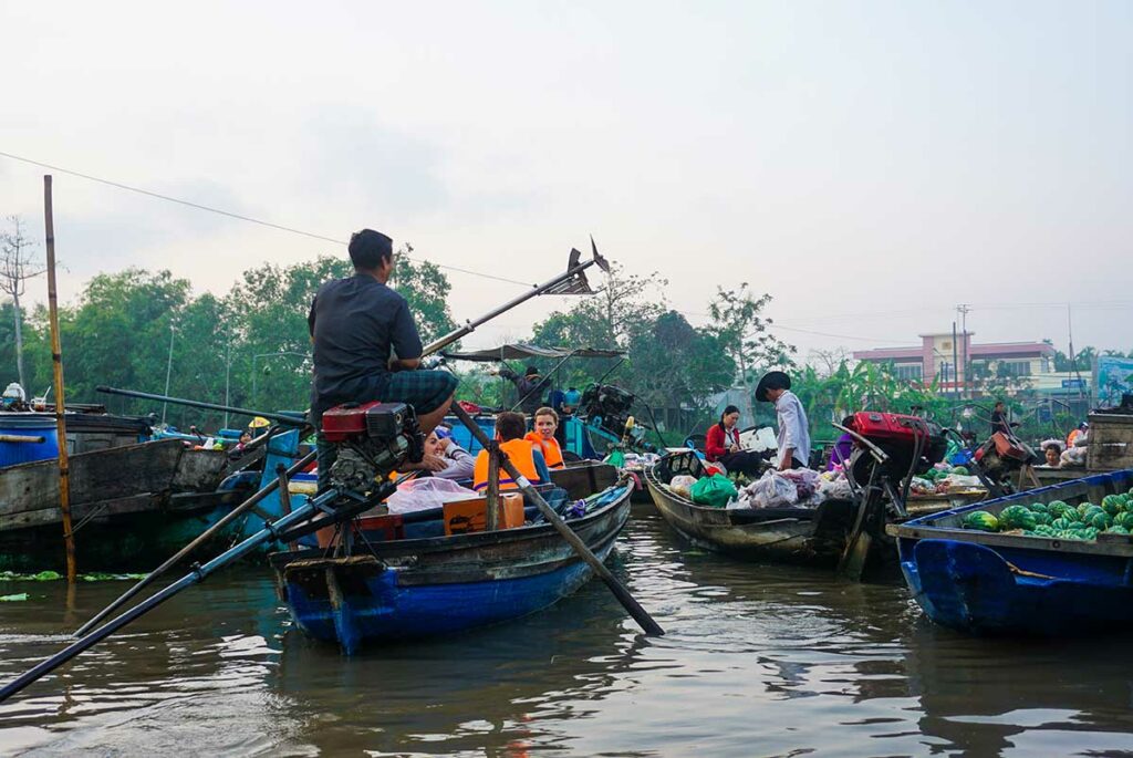 Small boats packed with fresh produce and locals trading at Phong Dien Floating Market on the Hau River, Can Tho.
