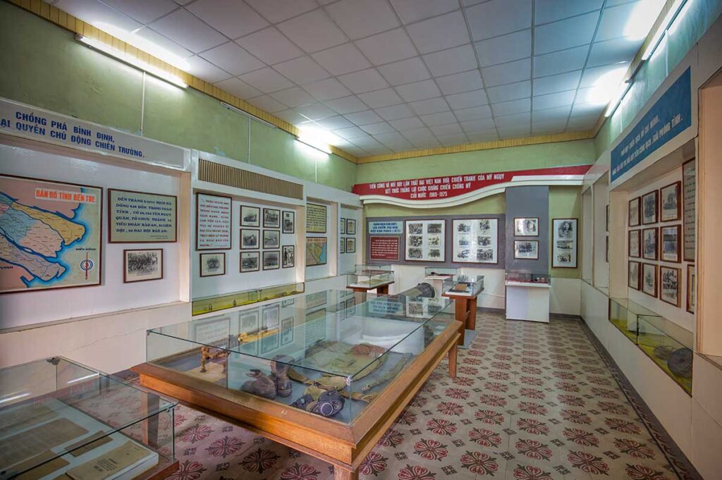 Exhibition hall inside the Ben Tre Revolutionary Museum in Vietnam with photos, maps, and war artifacts from the Dong Khoi uprising.