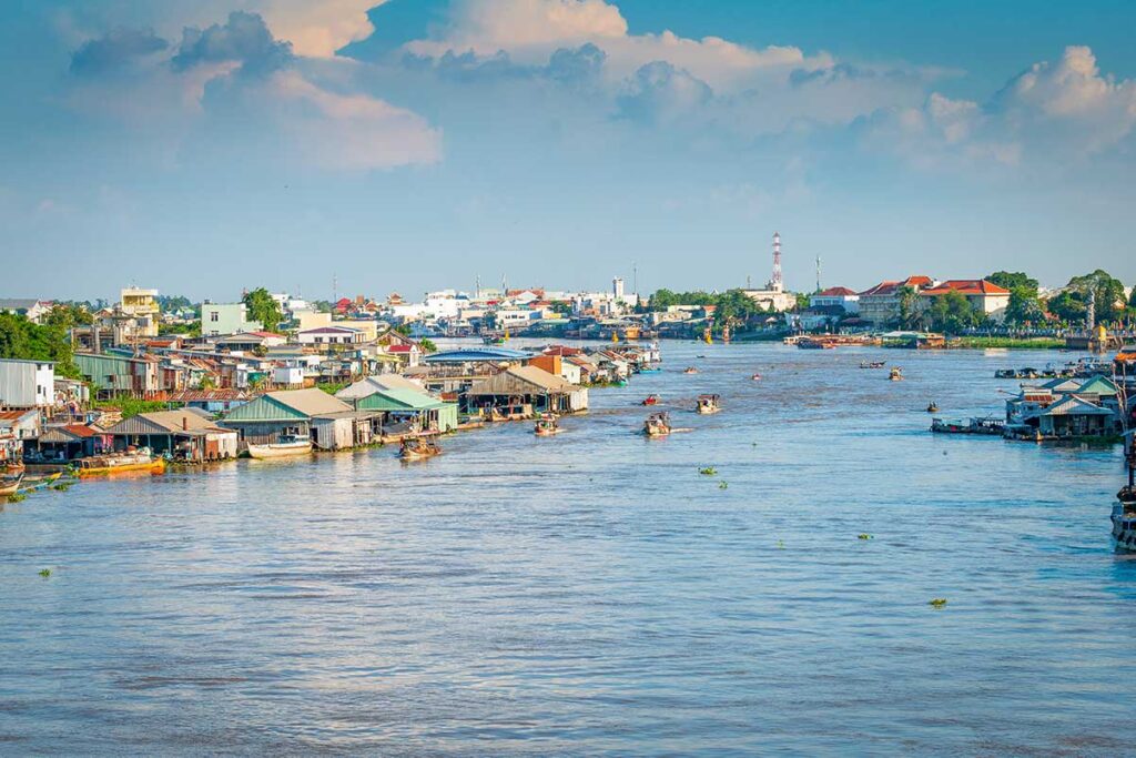 Panoramic view of Chau Doc town and Hau River with floating houses and trading boats in the Mekong Delta.