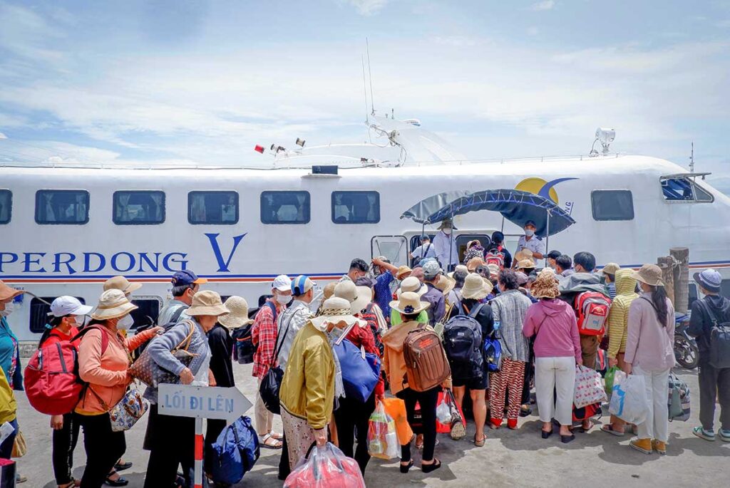 Ha Tien ferry port with passengers boarding boats to Phu Quoc Island.