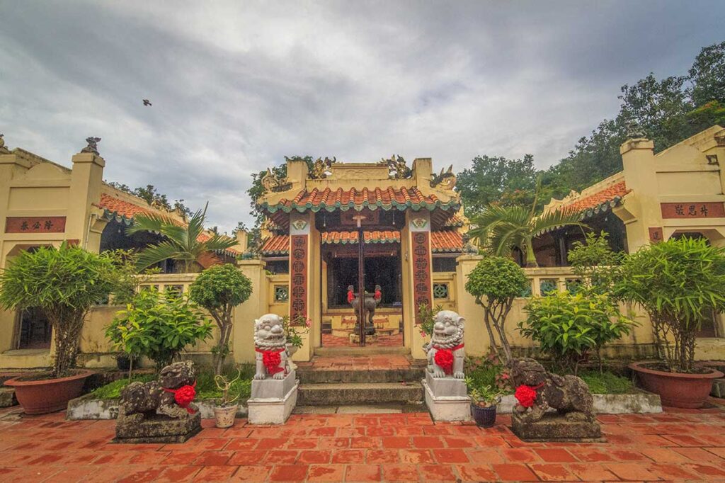 Inner courtyard of Mac Cuu Pagoda with altars and guardian lion statues.