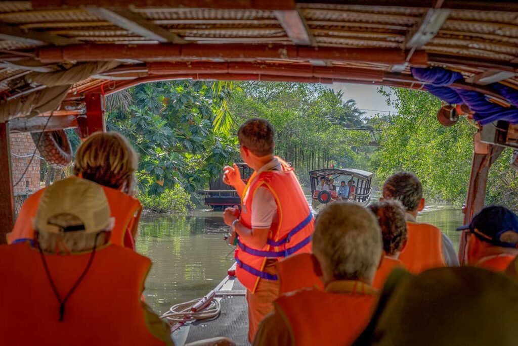 Tourists on a boat tour exploring canals near Sa Dec in Dong Thap