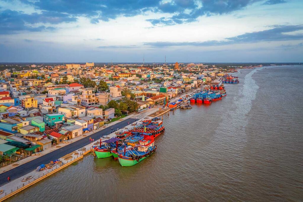 Fishing boats docked along the waterfront of My Tho, a vibrant river city in Tien Giang Province, Vietnam.