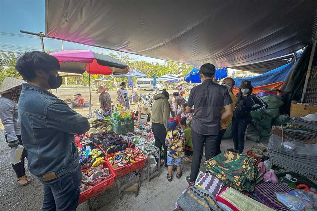 Local shoppers browsing clothes, shoes, and household goods at Tinh Bien Market near Chau Doc, a busy border market close to Cambodia.