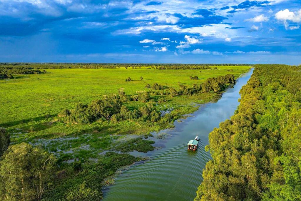 Aerial view of Tram Chim National Park with a boat gliding through the water