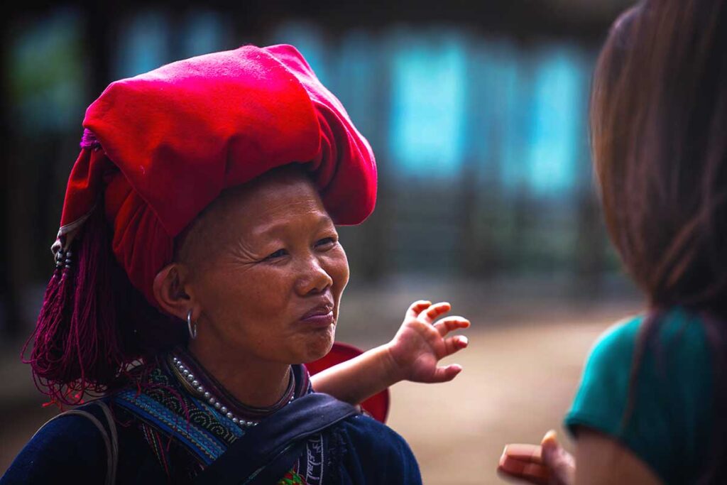 Red Dao woman talking to a woman foreign traveler