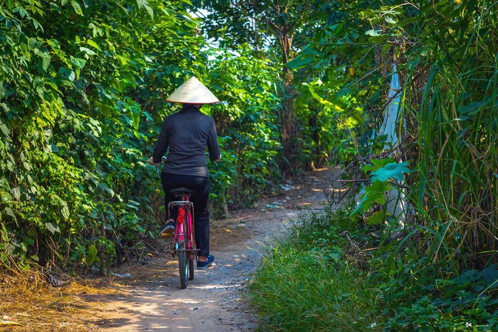 a local woman cycling through the banana plantations on Banana Island in Hanoi