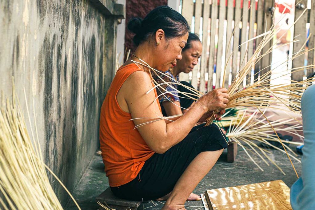 woman crafting a hand fan at Chang Son Village