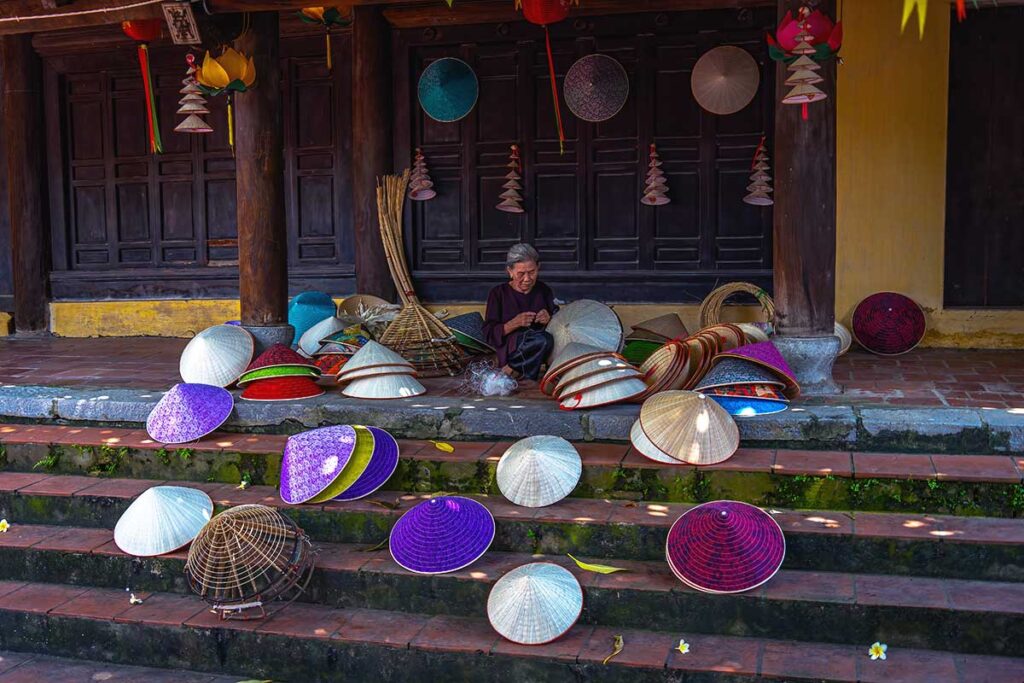 woman crafting traditional conical hats at Chuong Conical Hat Village near Hanoi