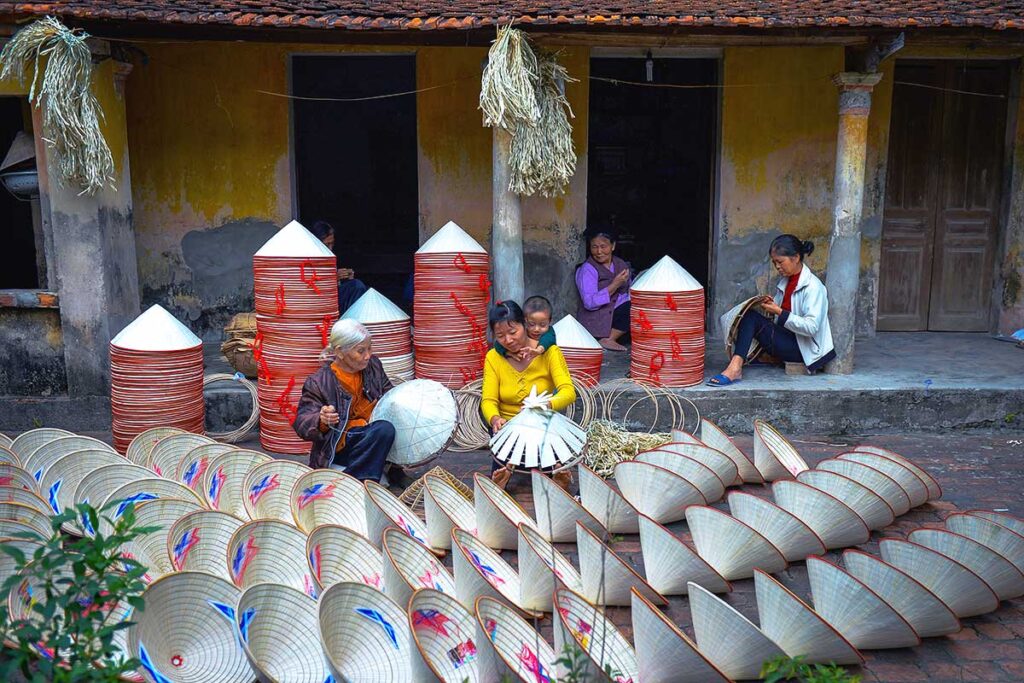 woman crafting traditional conical hats at Chuong Conical Hat Village near Hanoi