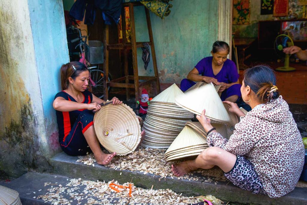 woman crafting traditional conical hats at Chuong Conical Hat Village near Hanoi