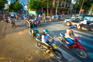 Pedestrian crossing in Vietnam crowded with motorbikes during busy traffic hours