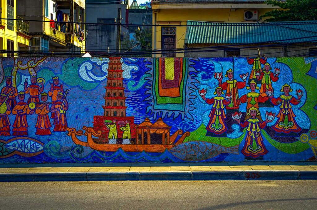 Hanoi Ceramic Mosaic Mural Thien Mu Pagoda: A vibrant mural on the Hanoi Ceramic Mosaic depicts the iconic Thien Mu Pagoda and dragon boats on the Perfume River in Hue.