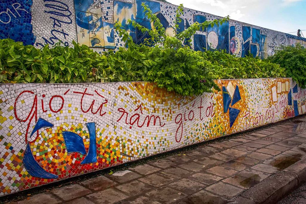 Hanoi Ceramic Mosaic Mural Contemporary Art: A modern art mural on the Hanoi Ceramic Mosaic features the Vietnamese text "Gio tu nam gio toi," adding a contemporary touch to the traditional mosaic.