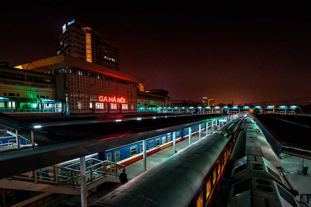 Night view of Hanoi Railway Station with sleeper trains parked, captured from the overhead path connecting platforms.