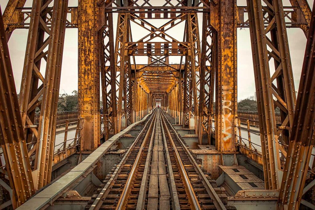 Long Bien Bridge from Train Tracks: A unique perspective of the historic Long Bien Bridge in Hanoi, captured from the train tracks running alongside its steel beams.