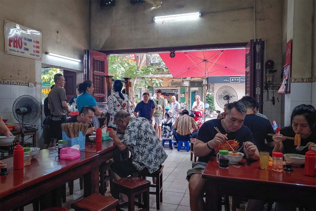 Pho Bat Dan Hanoi: Local diners enjoy steaming bowls of pho, Vietnam's iconic noodle soup, at Pho Bat Dan, a popular Hanoi eatery.