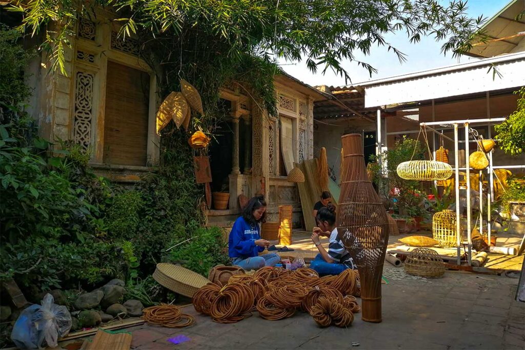 Vietnamese villagers create decorative bamboo pieces outside a workshop in Phu Vinh, a renowned handicraft village.