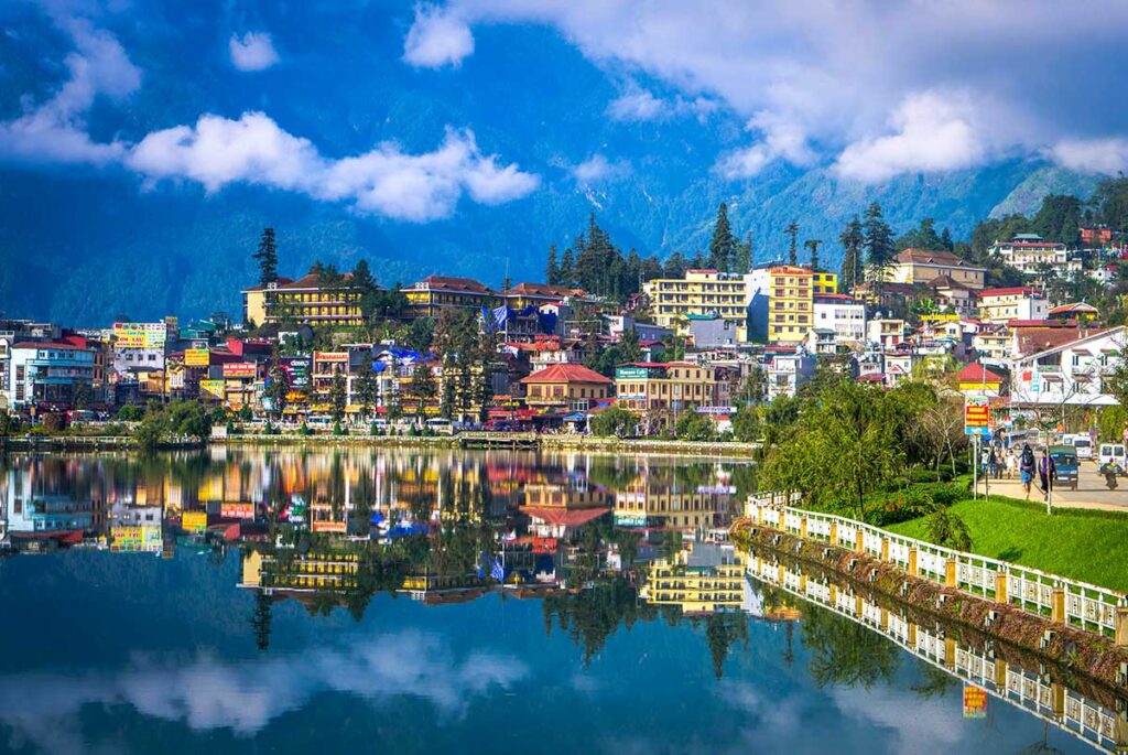 Sapa Town with Mountain Backdrop: Sapa town nestles in a valley with a picturesque lake and majestic mountains rising in the background.