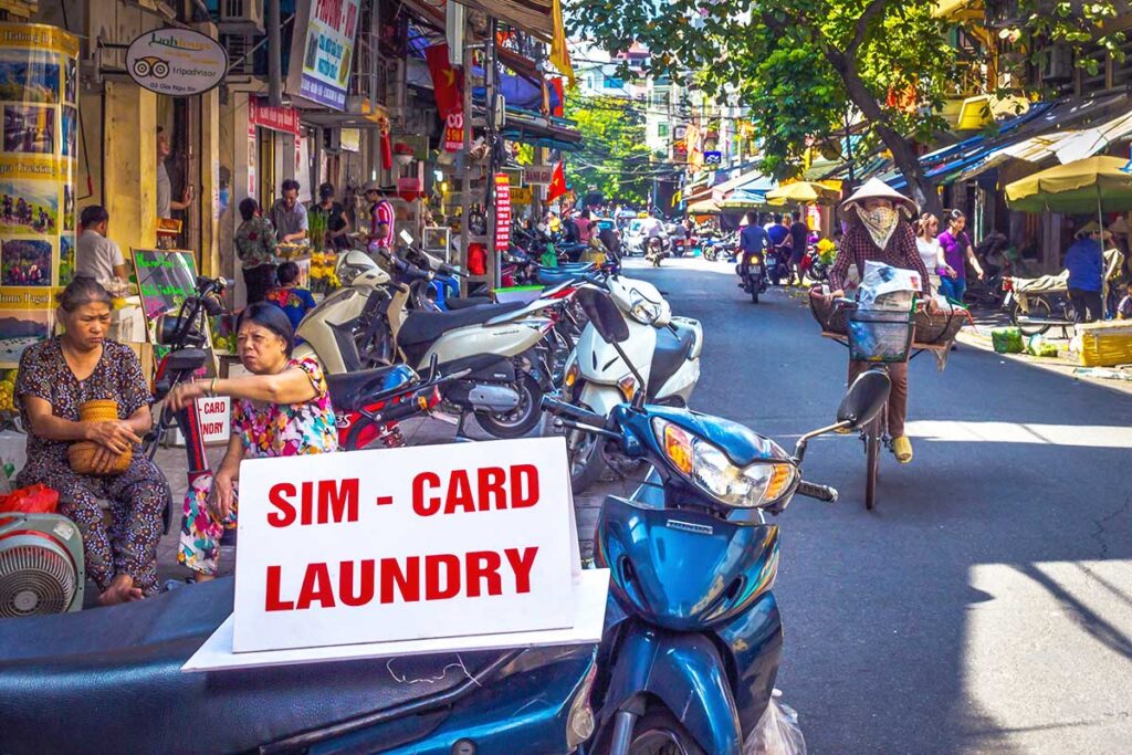 Street sign offering laundry and SIM card services in Vietnam – Vietnam travel tips for using local laundry services