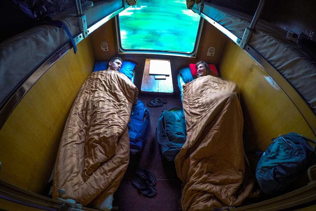 Foreign travelers sleeping in a cozy 4-berth cabin of a sleeper train in Vietnam.