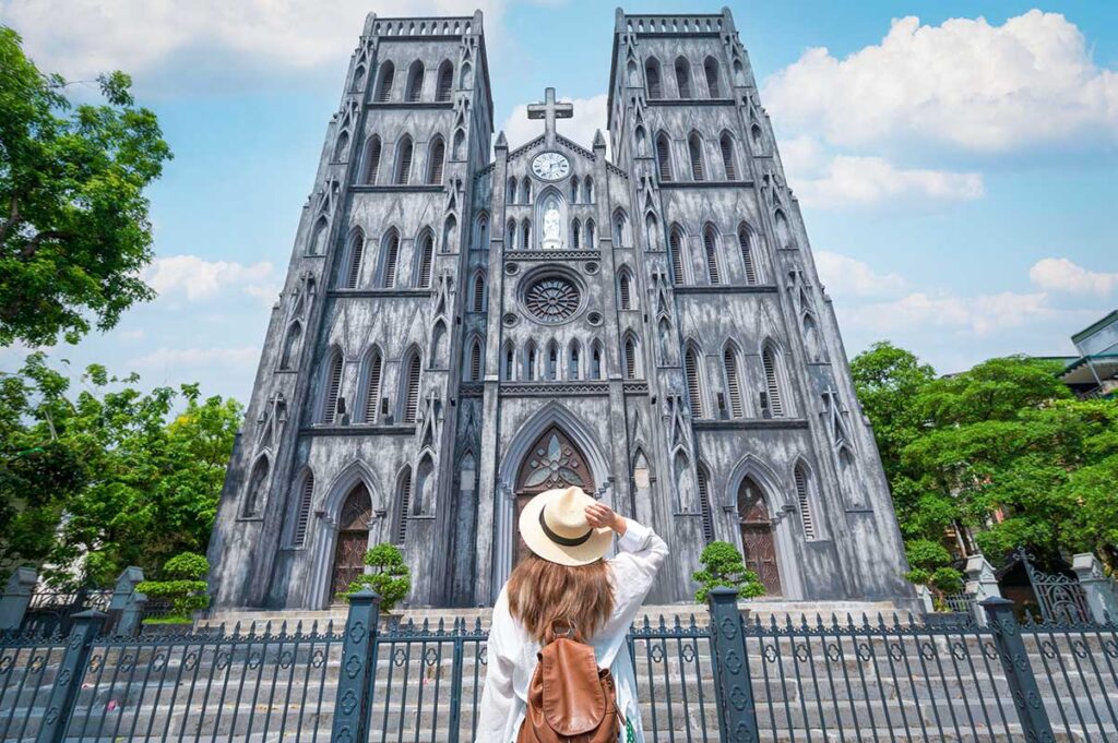 Tourist at St. Joseph's Cathedral: A woman admires the architectural details of St. Joseph's Cathedral in Hanoi.