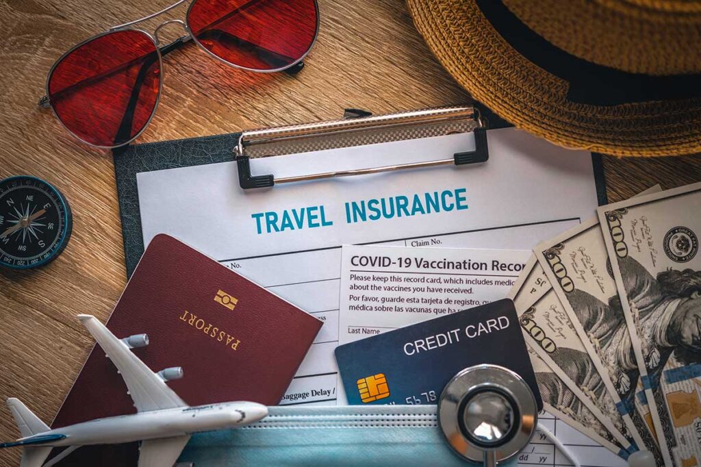 Travel insurance documents with a credit card, passport, and other travel essentials, highlighting the importance of being prepared for a trip to Vietnam.