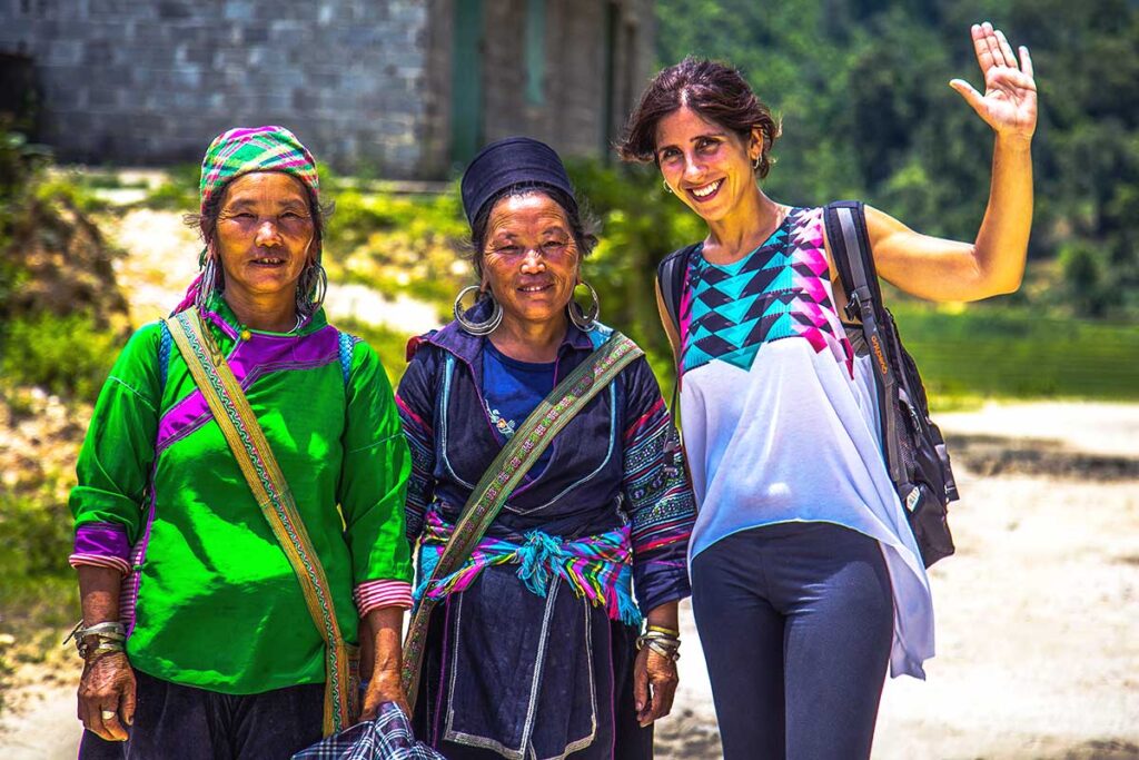 A tourist woman doing a trekking in Sapa and meets two ethnic minority woman