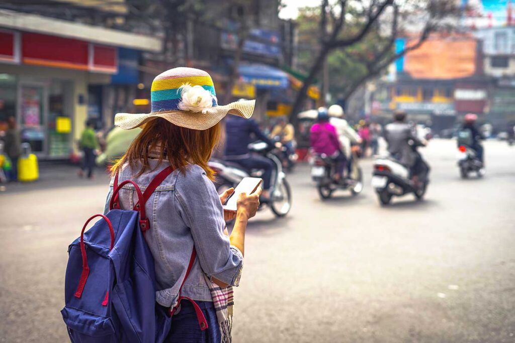 Female traveler using her phone on the street in Vietnam