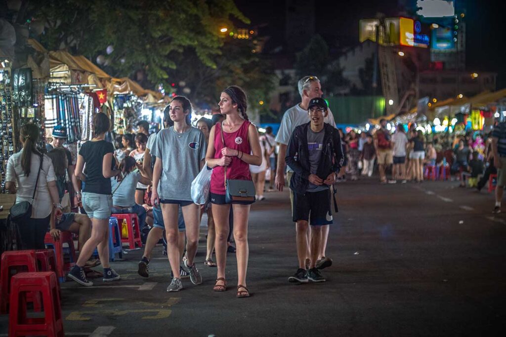 Tourists walking through Ben Thanh Night Market in Ho Chi Minh City