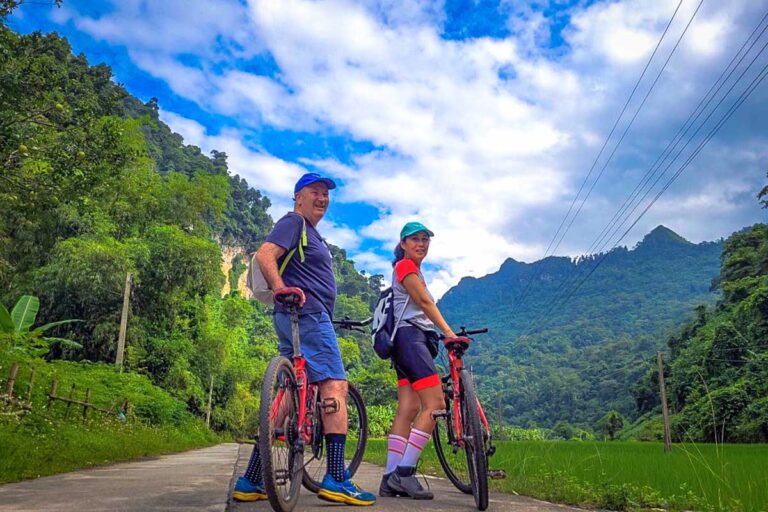 Two tourists cycling over a quiet road in Ba Be National Park