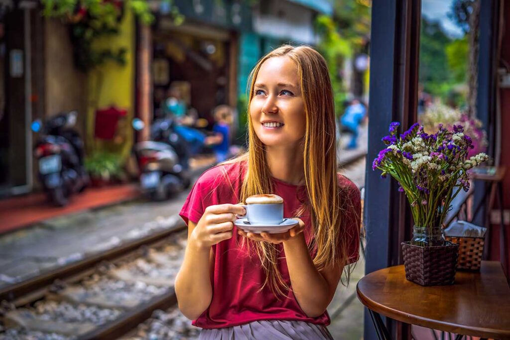 A woman drinking Vietnamese Egg Coffee in Hanoi Train Street