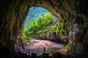 A huge cave opening with jungle inside and small river at Hang En Cave, Phong Nha, Vietnam