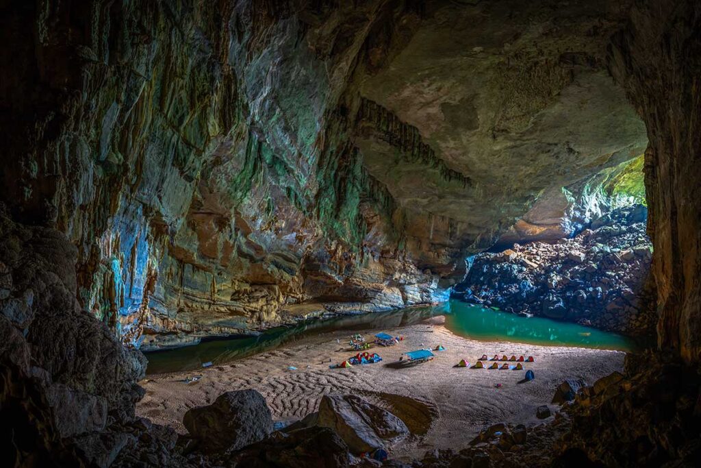 A campsite with beach and lake inside Hang En Cave