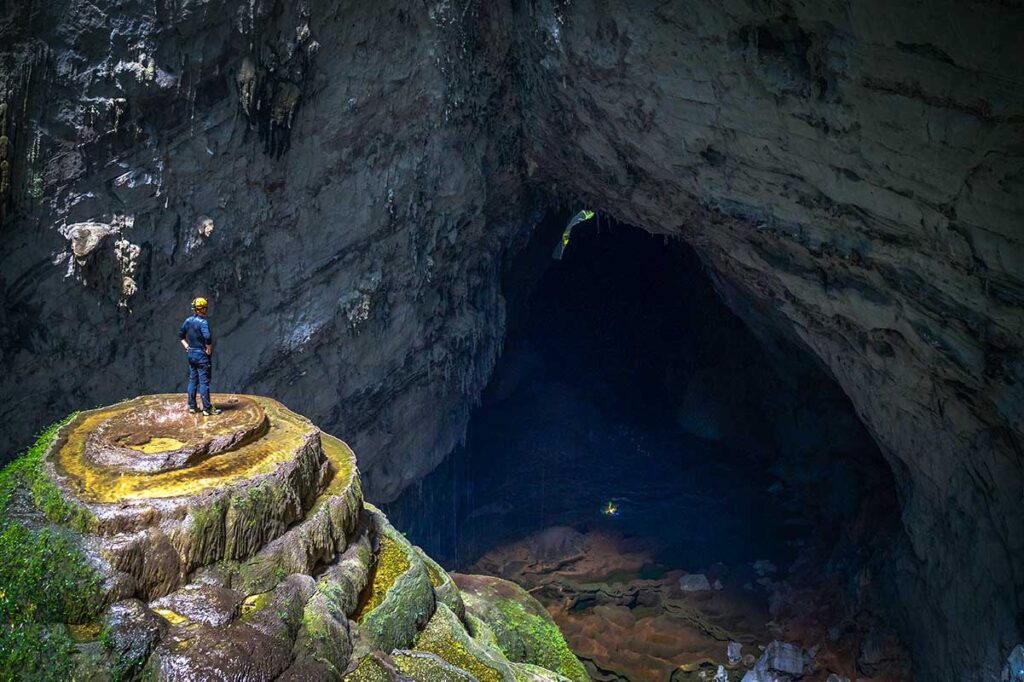 A traveler standing on a beautiful rock formation inside Hang Son Doong Cave