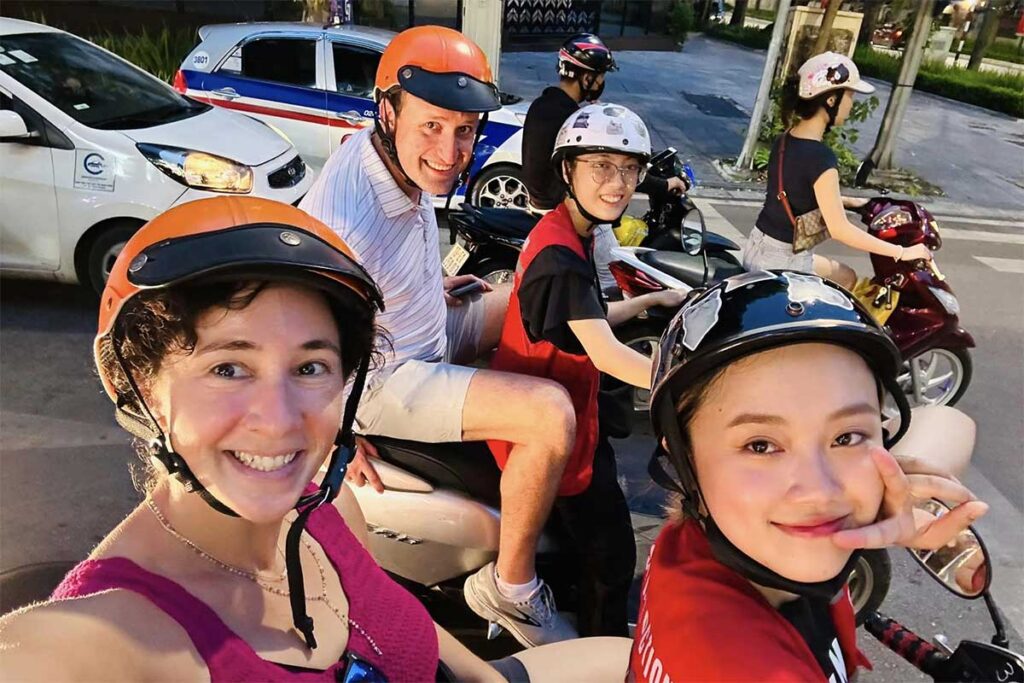 Two tourists on the back of motorbikes with local guides, discovering hidden gems and off the beaten places in Hanoi