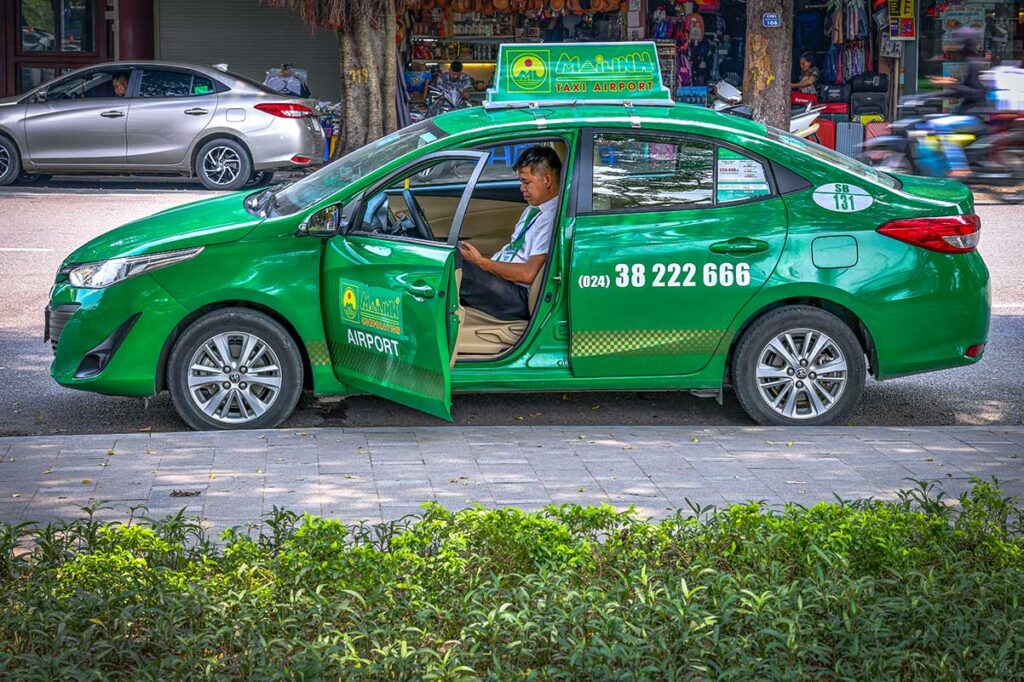 A green Mai Linh Taxi in Hanoi