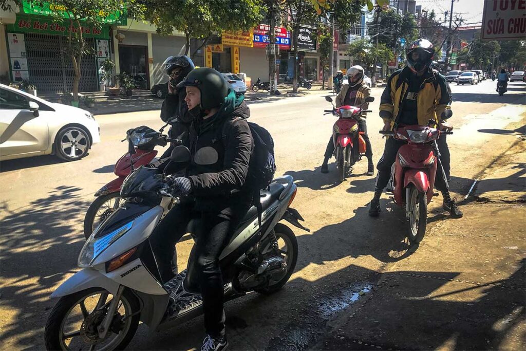 Three foreign tourists renting a motorbike in Lang Son at a motorbike rental shop in the city