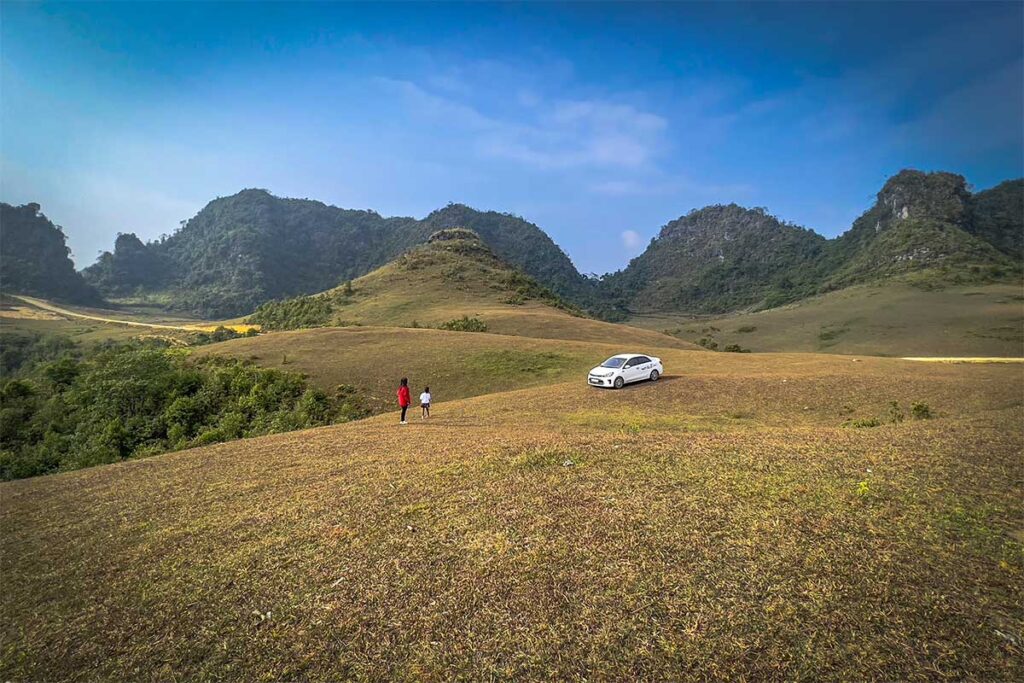 Large grass fields on hills surrounded with mountains of Phan Thanh Grass Hills on Phia Oac National Park