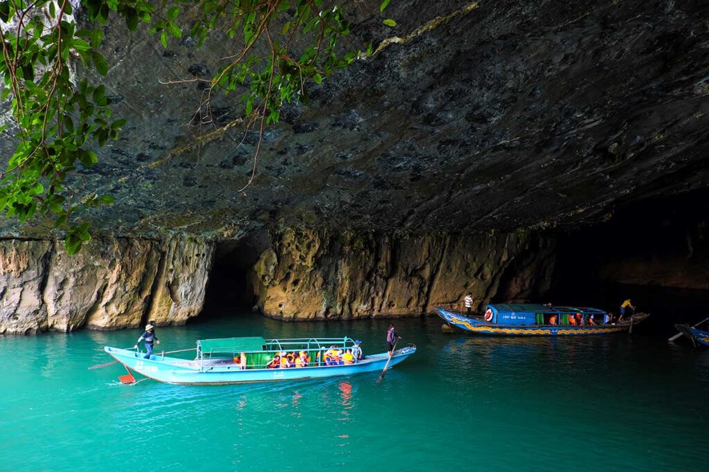 Two boats going through the entrance of Phong Nha Cave