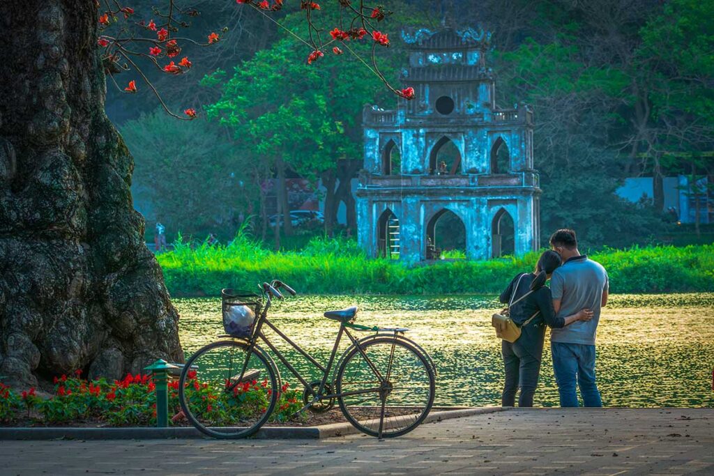 A couple holding each other at Hoan Kiem Lake in Hanoi - Romantic Vietnam